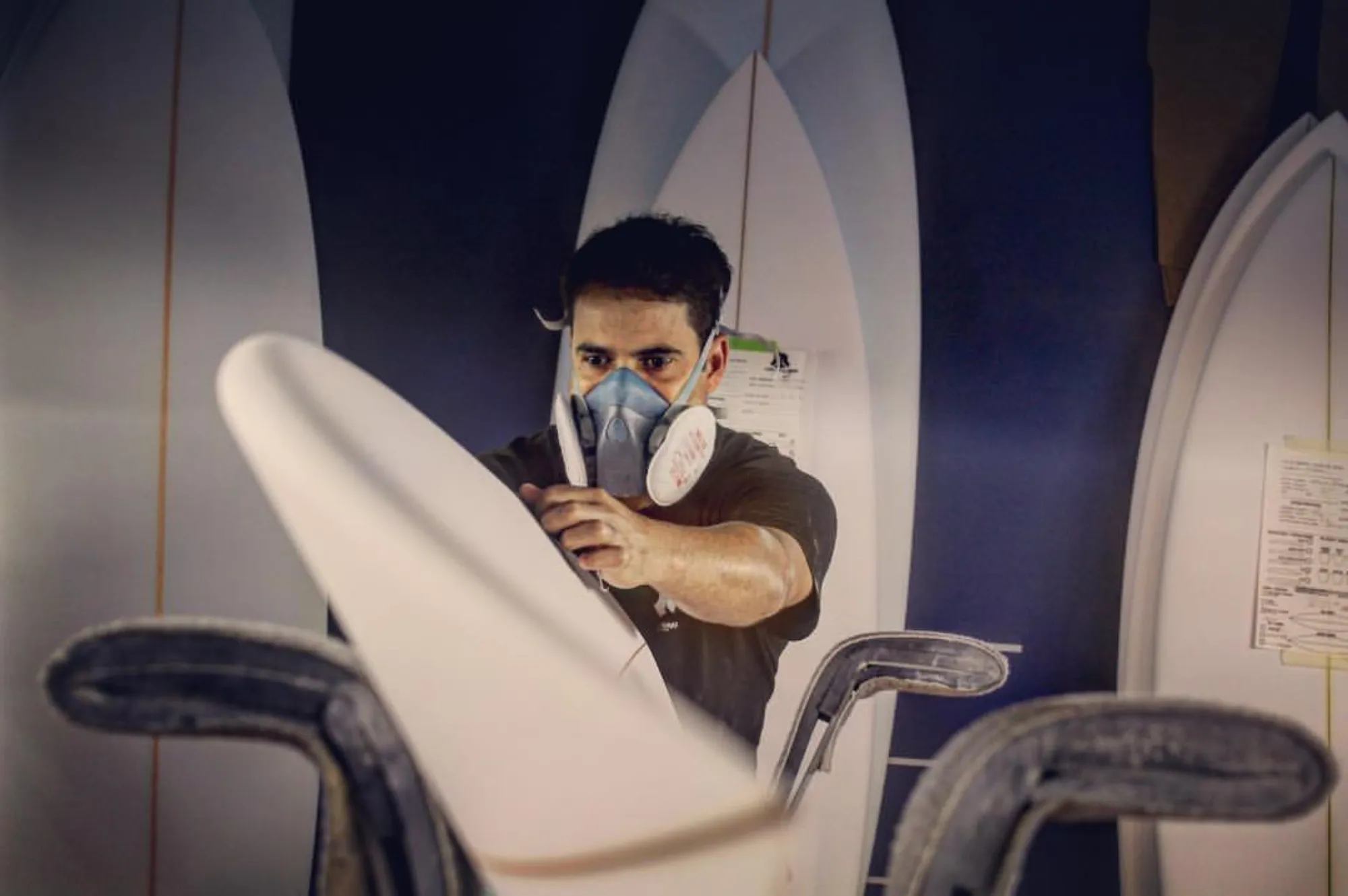 Alessandro Pierre shapant une planche de surf dans son atelier